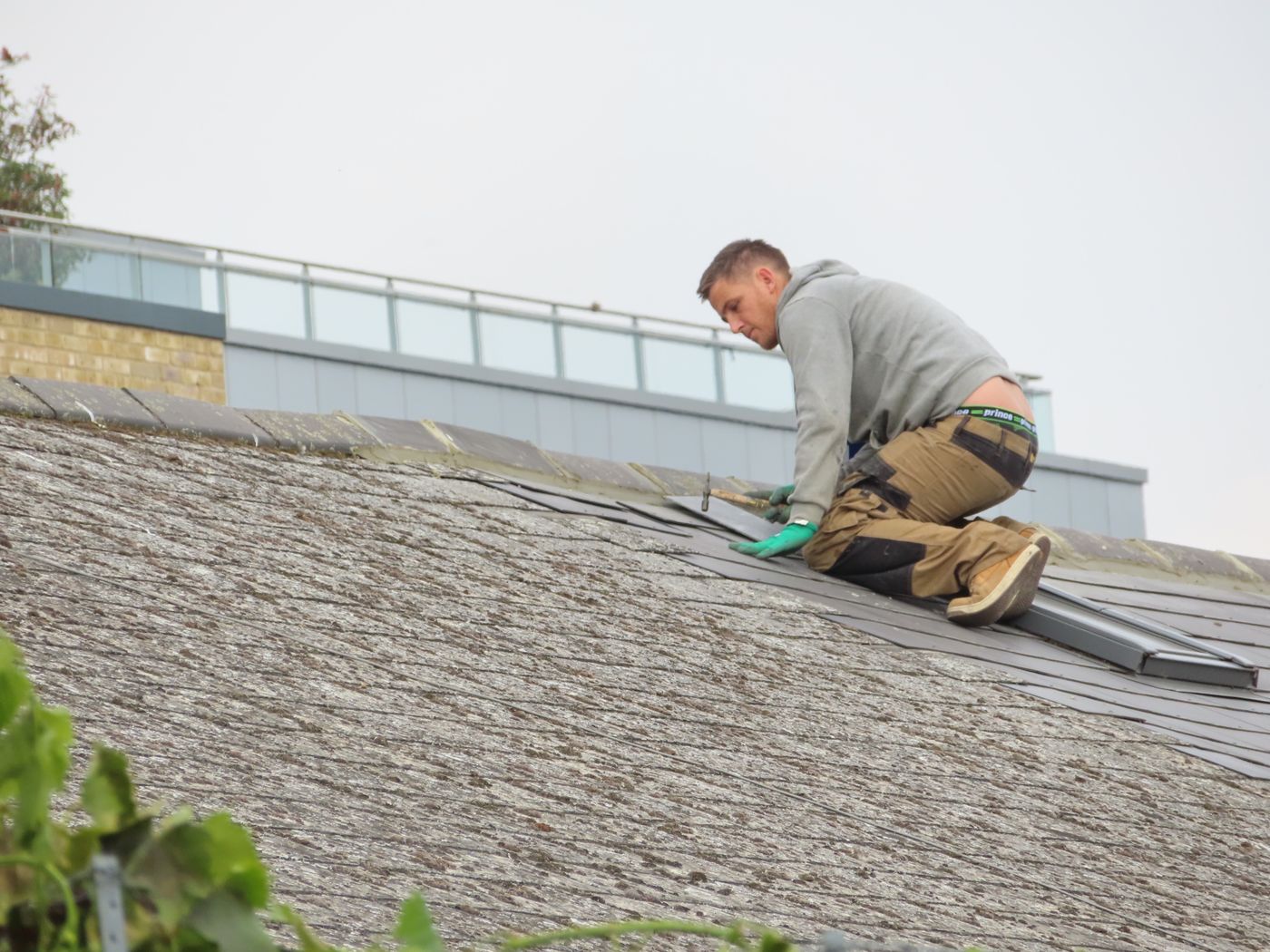 A contractor installing shingles on a residential roof